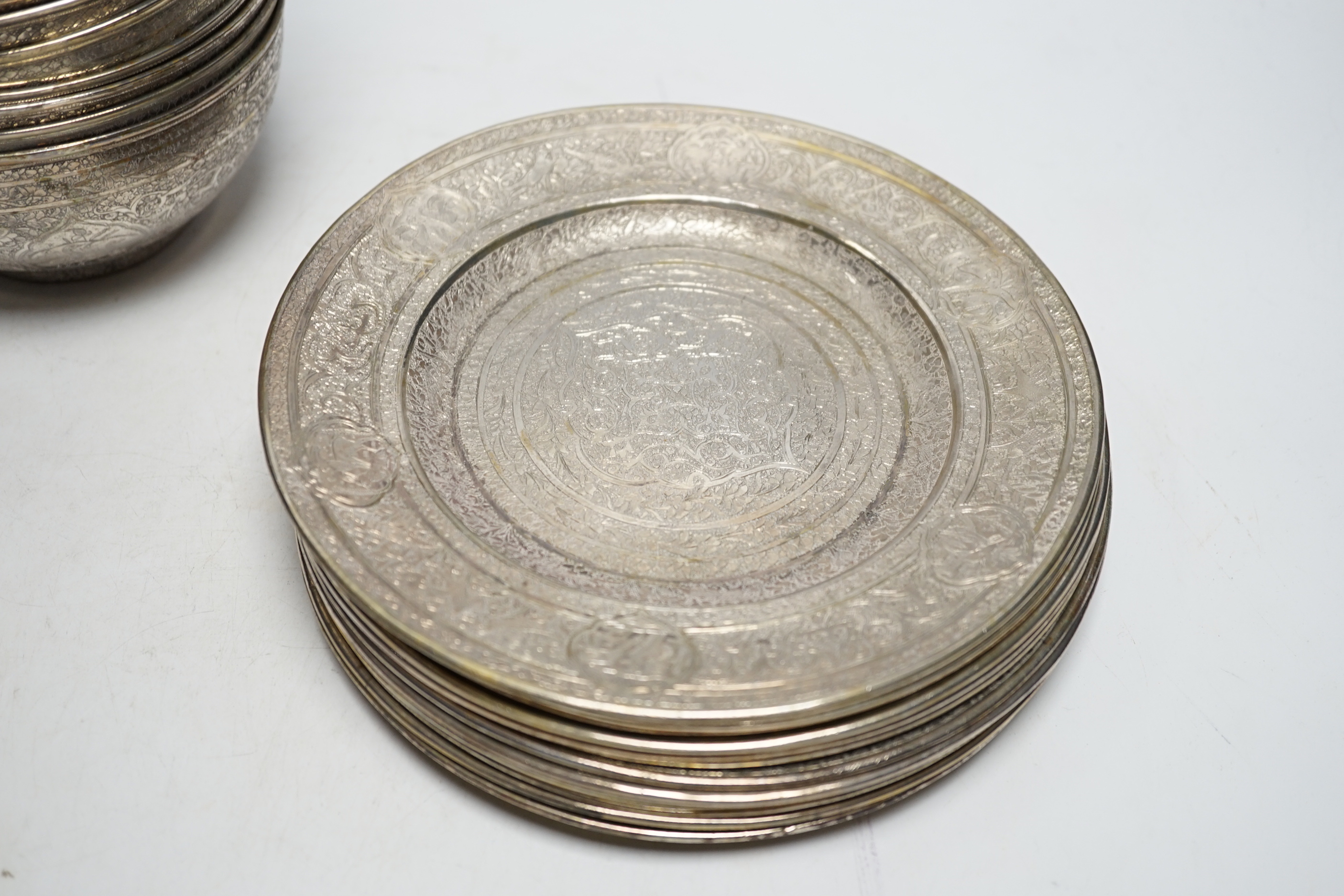 A set of twelve Persian engraved white metal bowls and matching stands/side plates?, bowl diameter 112.8cm, 146.7oz.